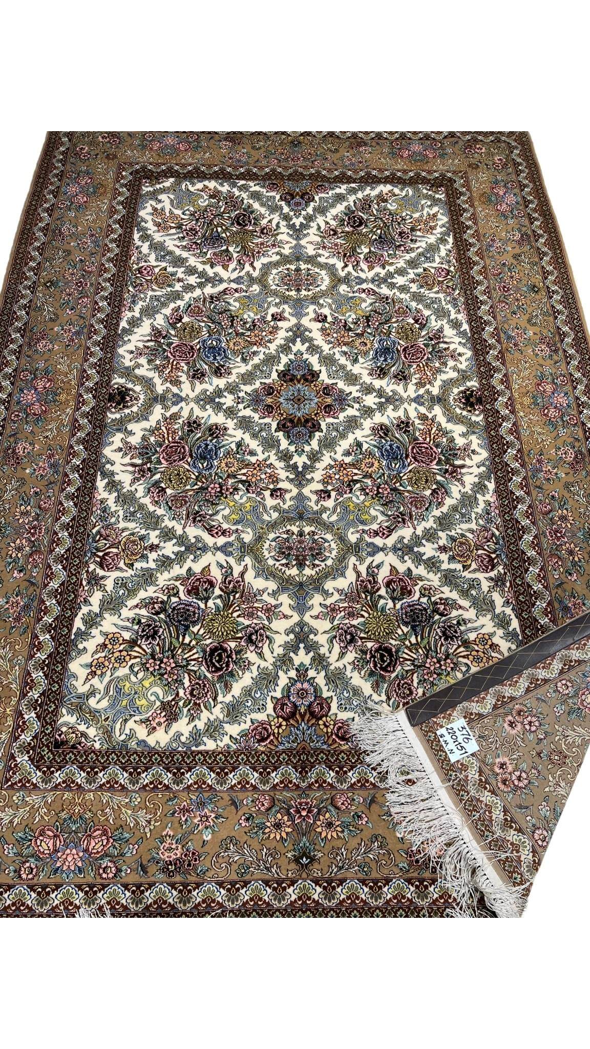 "215 x 145 cm wool and silk carpet with intricate floral patterns."